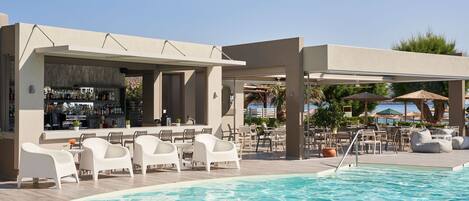 A poolside area with a bar, white lounge chairs, and outdoor seating.