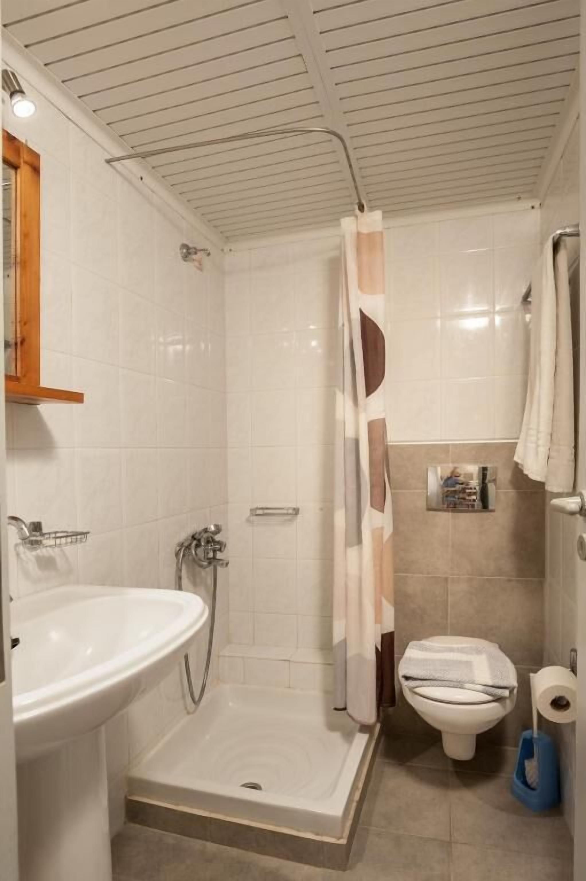 Une salle de bain équipée d’une douche, de toilettes, d’un lavabo et d’un porte-serviettes.