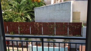 A residential area with a swimming pool, a fenced garden, and a view of neighboring buildings. - Niriis Hotel (Chania)