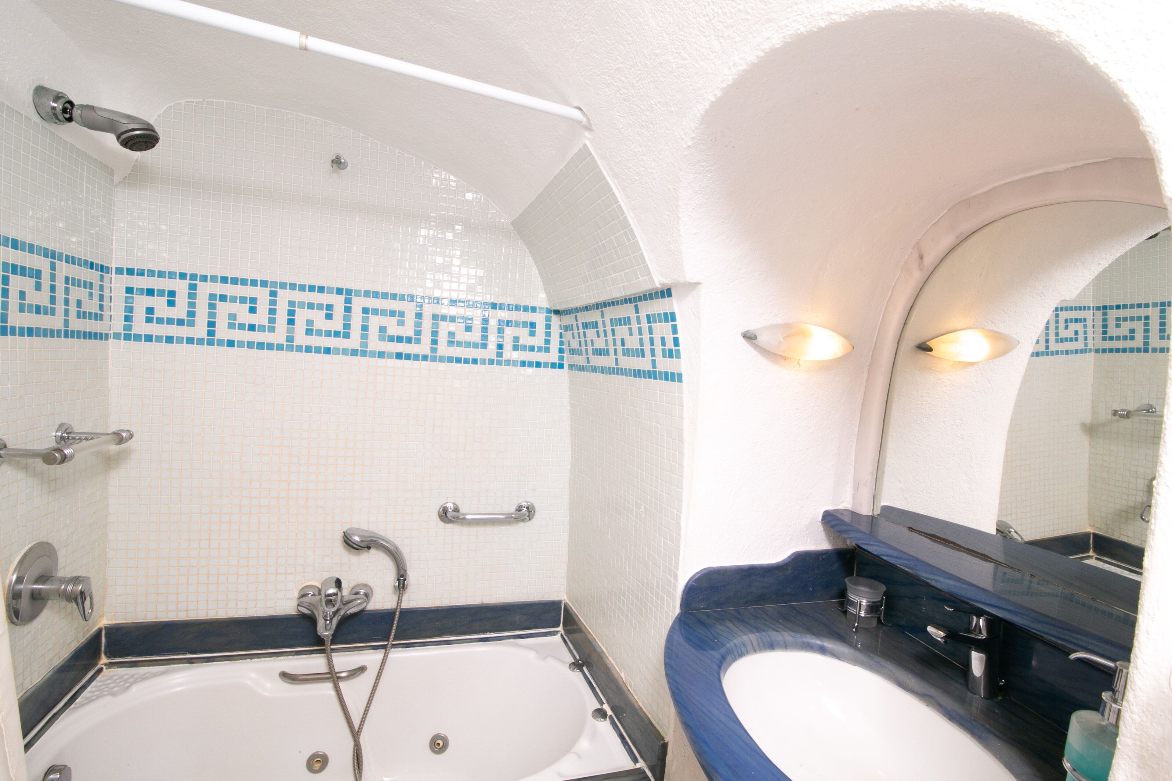 Un baño con bañera, lavamanos y espejo.