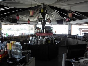 A bar area with a counter, various bottles, and hanging lanterns.