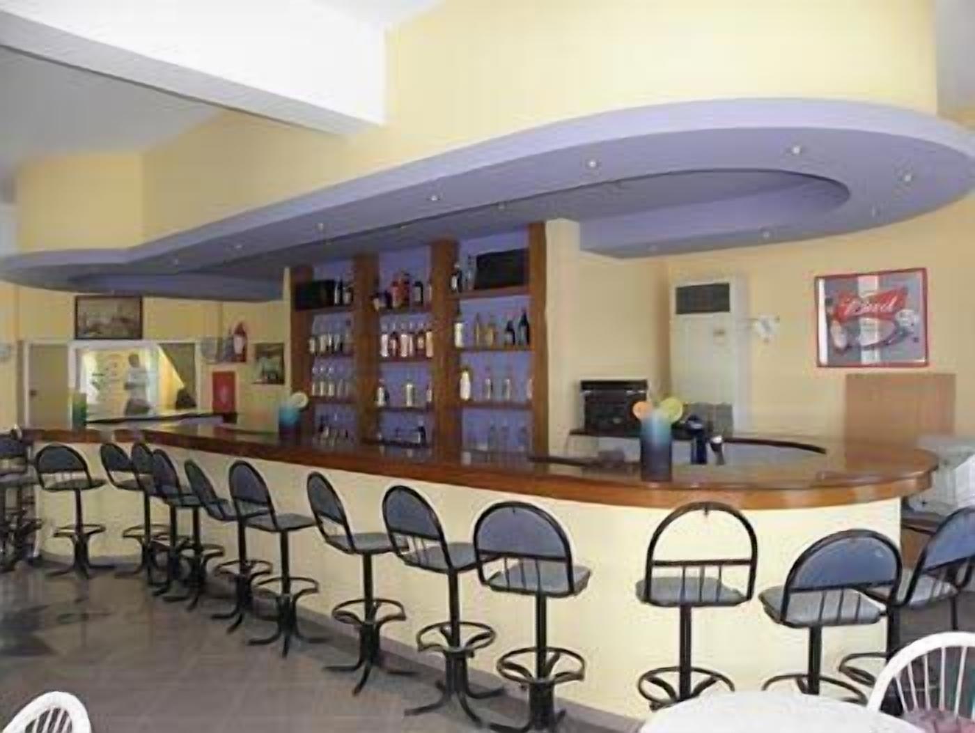A bar area with a counter and multiple chairs.