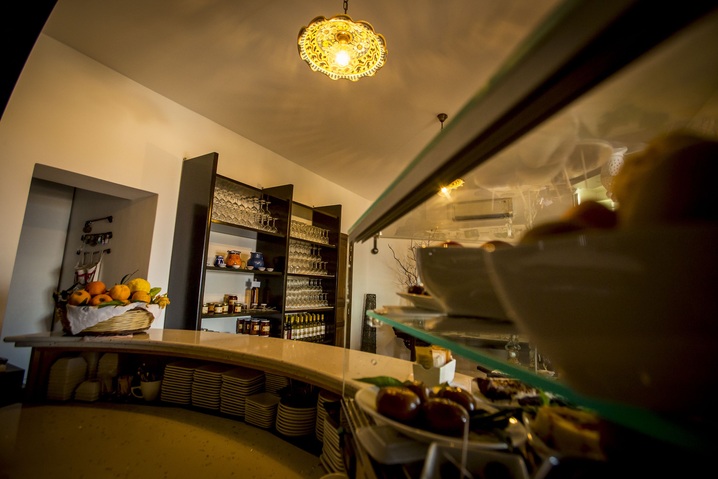 Una cocina con mostrador exhibiendo frutas y una vitrina con pasteles.