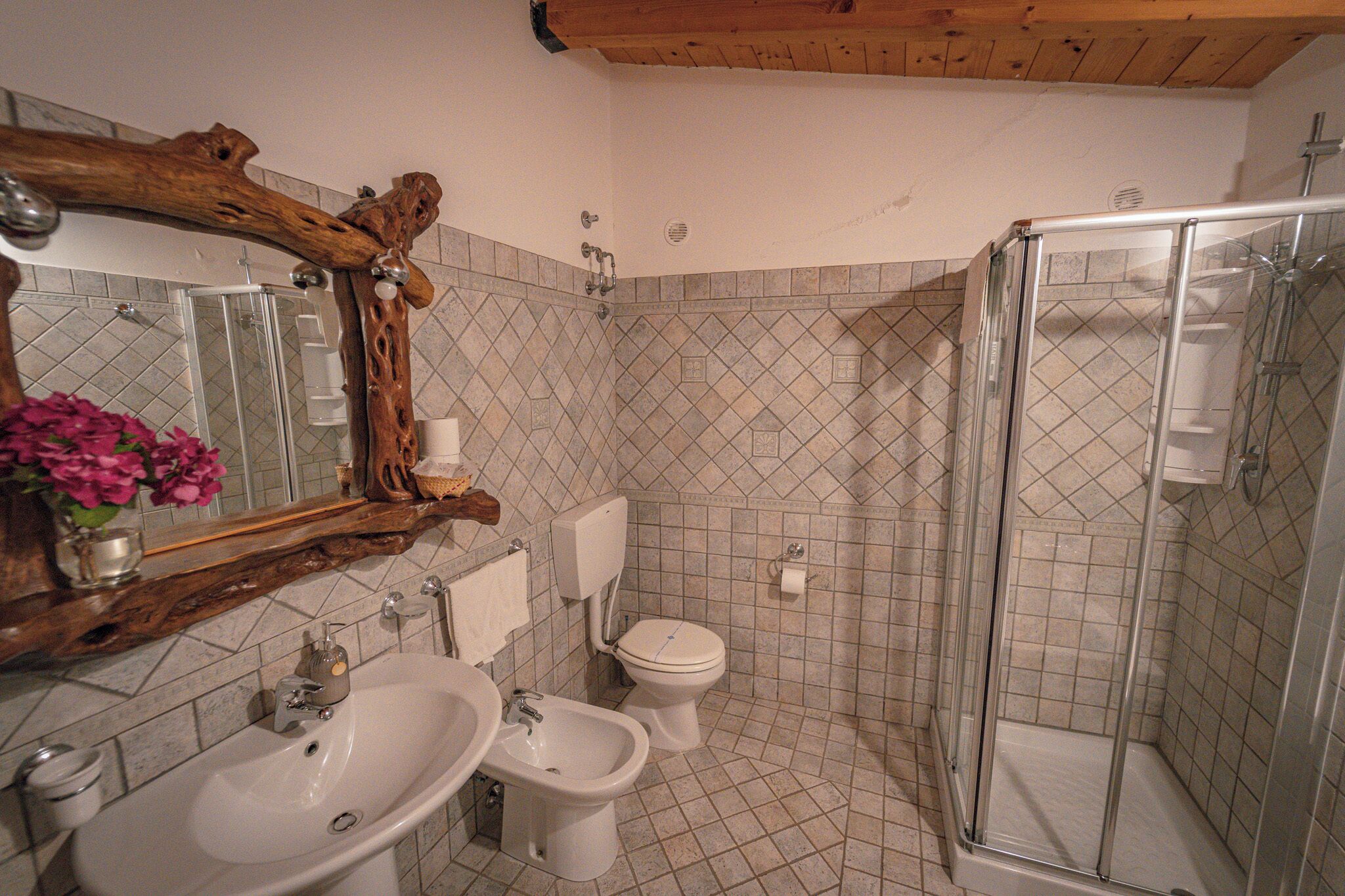 Ein Badezimmer mit großem Spiegel, zwei Waschbecken, Toilette und einer Duschkabine.