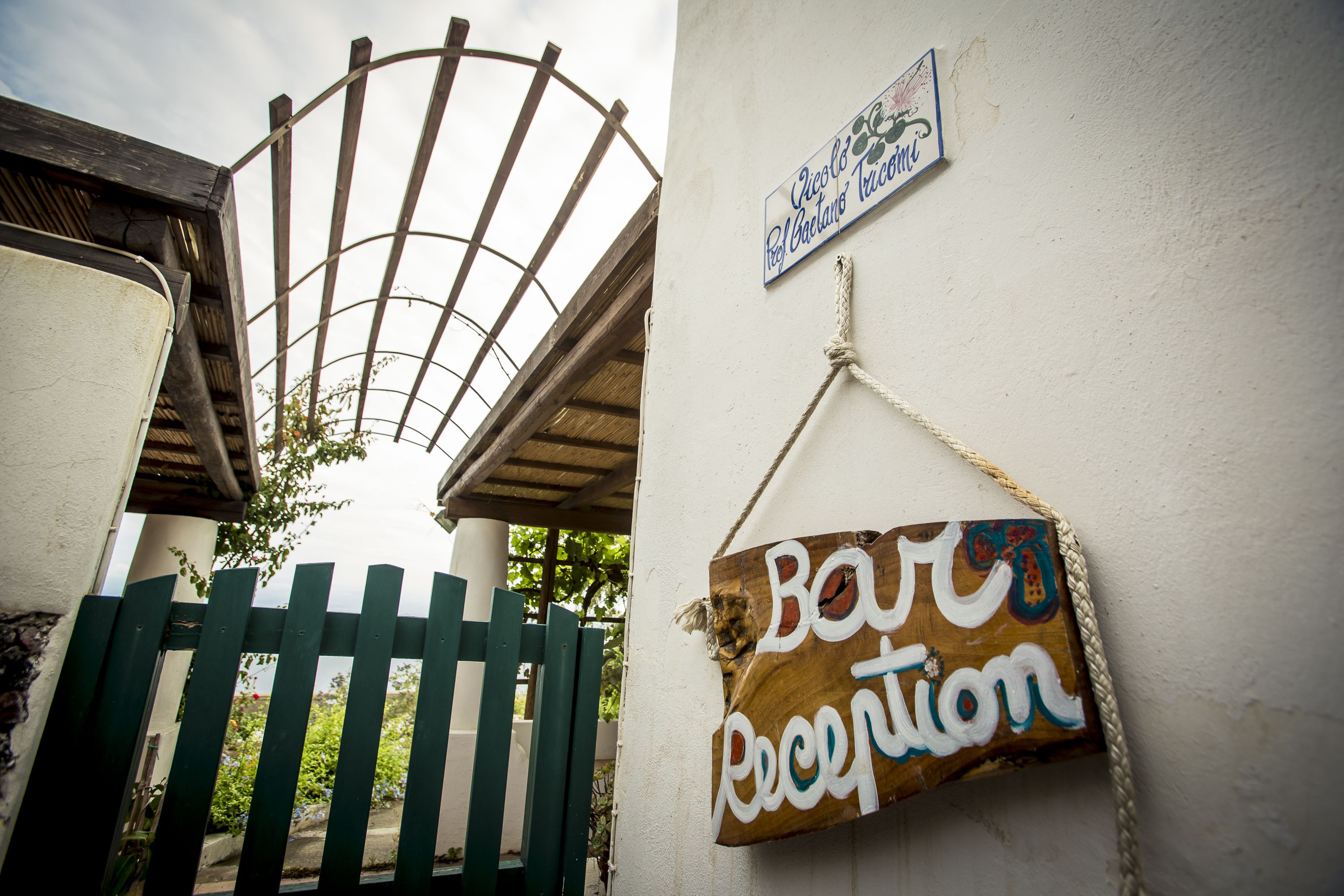 A wooden gate, a sign reading "Bar Reception", and a sign with a logo and text.