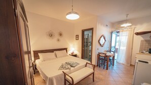 A bedroom with a bed, bedside tables, a desk, and a chair. - Al Belvedere Salina (Leni)
