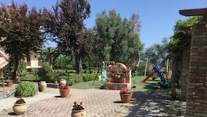Un patio empedrado con macetas y una fuente de piedra.