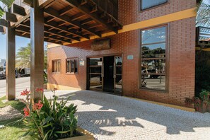 A brick building with a covered entrance, large windows, and a sign above the door. - Hotel Pirá Miúna (Bonito)