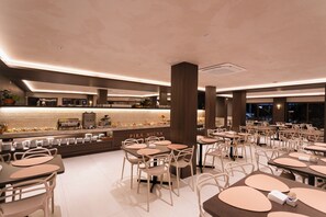 A modern restaurant with a long counter, multiple tables, and chairs. - Hotel Pirá Miúna (Bonito)