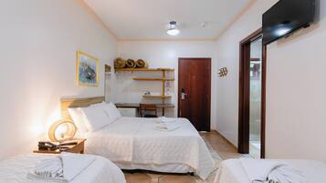 Camera d'albergo con due letti, una scrivania, una sedia, una televisione e un'uscita che dà su un balcone.