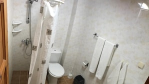 Ein Badezimmer mit Dusche, Toilette, Bidet und Waschbecken.
