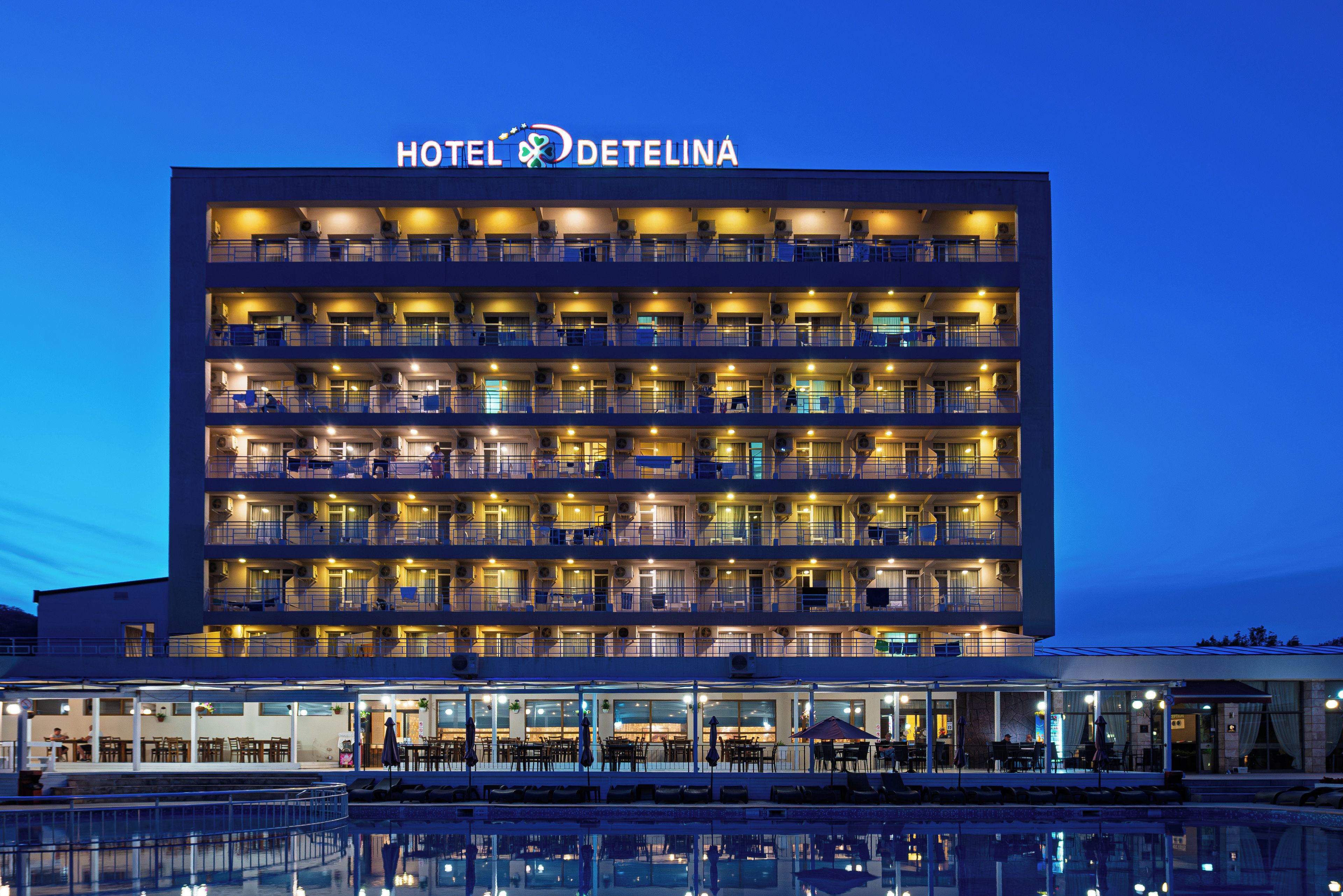 A multi-story hotel with balconies, a pool, and outdoor seating.