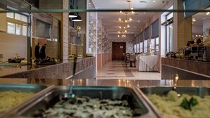 A buffet area with a variety of food options, a long counter, and a seating area with tables and chairs. - Detelina (Varna)