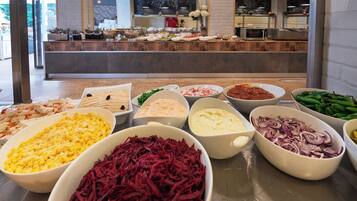 A buffet with various food items in bowls.