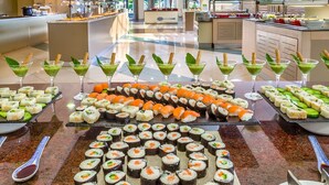 Un espace buffet proposant des sushis et des boissons vertes.