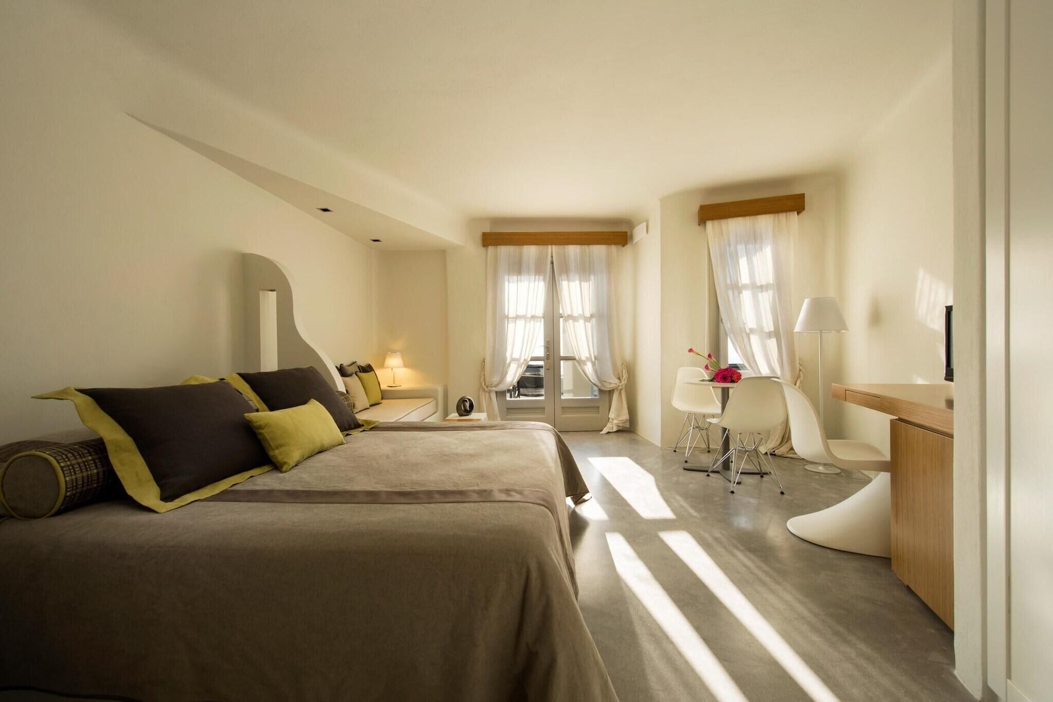 Una habitación de hotel con cama, mesitas de noche, escritorio y silla.