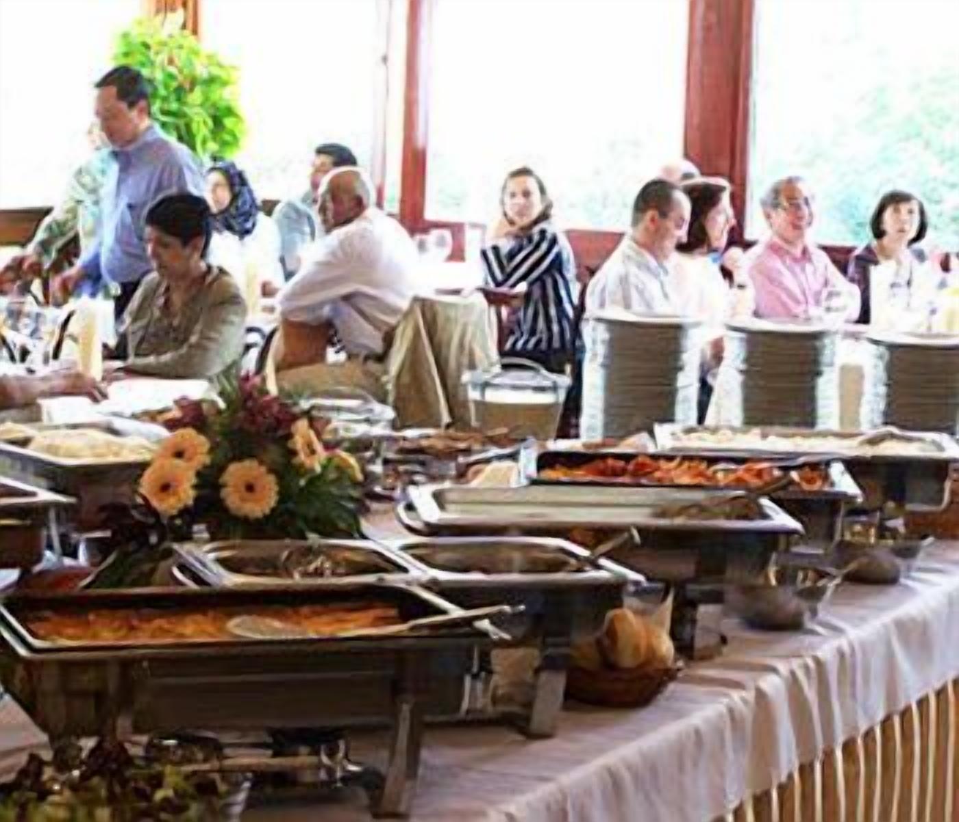 A buffet setup with various food items and a floral centerpiece.