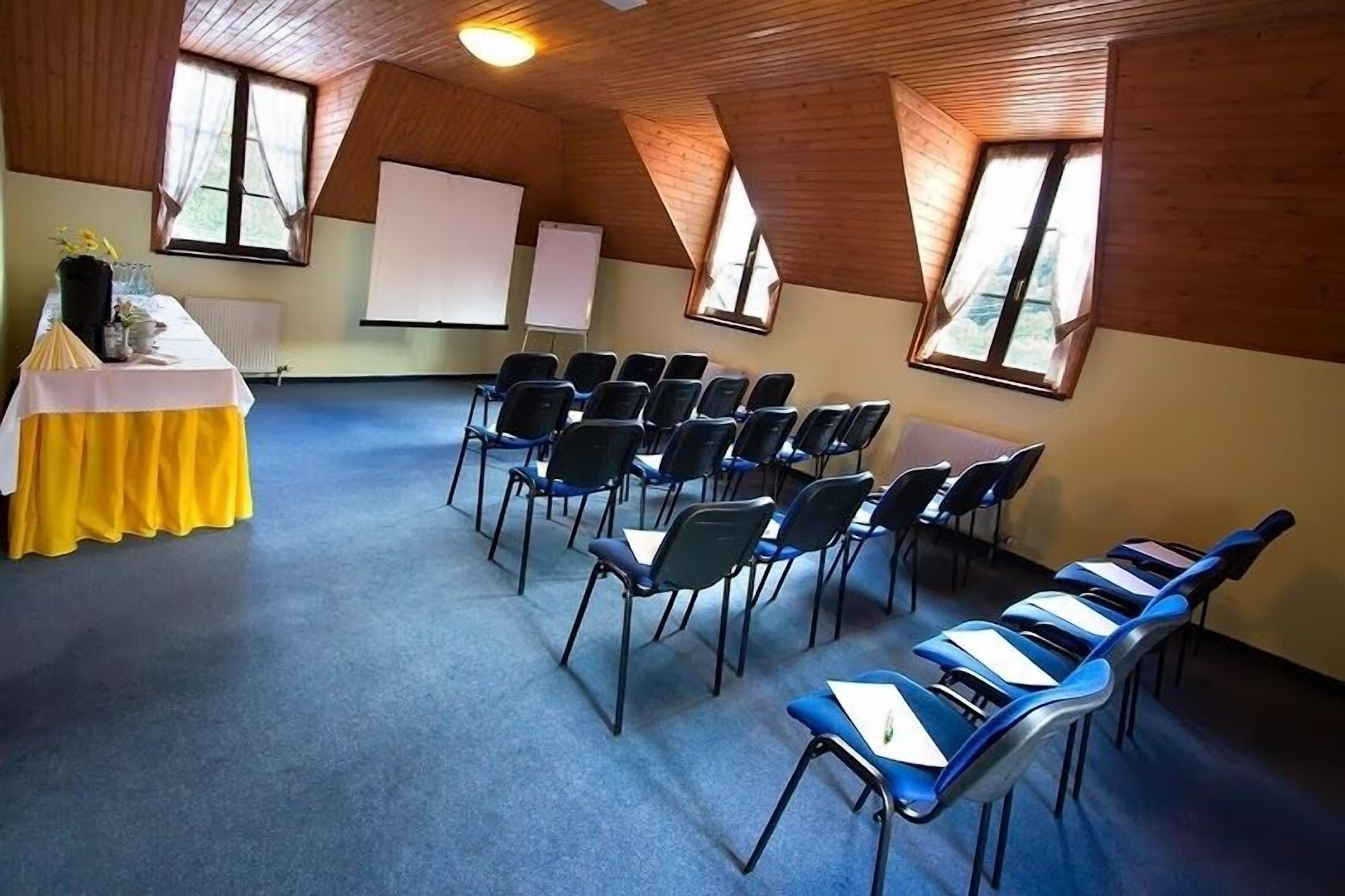 Ein Konferenzraum mit einem langen Tisch, Stühlen und einer Whiteboard-Tafel.