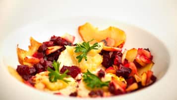 A white plate with a salad consisting of diced fruits and vegetables, garnished with parsley.