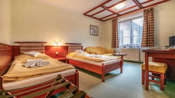 Habitación de hotel con dos camas, un escritorio y una silla.