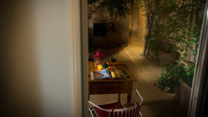 Un coin repas chaleureux avec une table en bois, des chaises et un vase de fleurs.