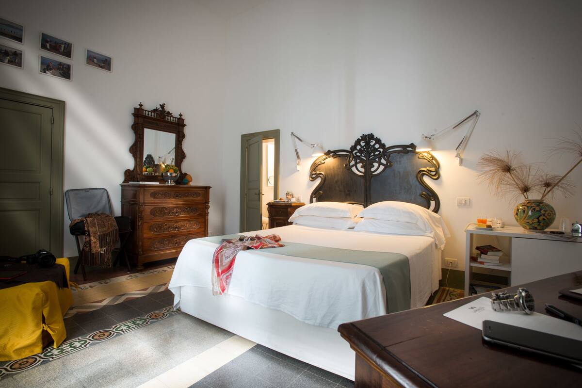 Een keurig opgeruimde slaapkamer met een bed, een dressoir en nachtkastjes.