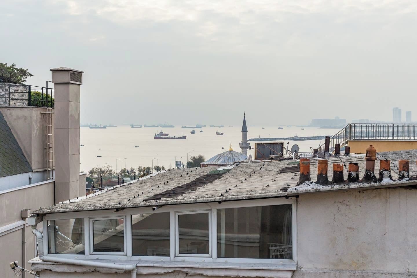 Un edificio con vista a una masa de agua, una mezquita y varios barcos.