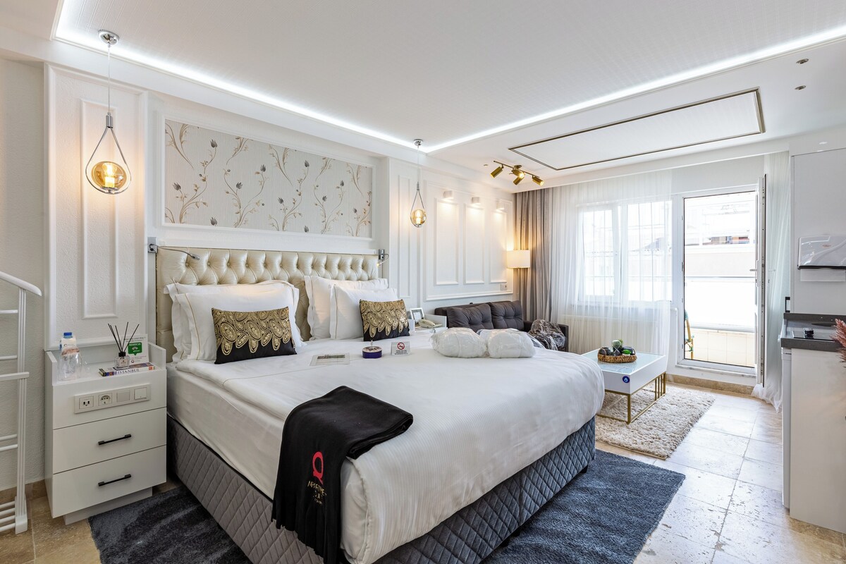 Een hotelkamer met een groot bed, nachtkastjes, een bureau en uitzicht.
