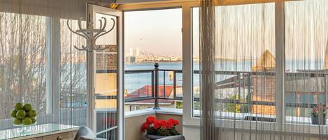 A room with a view of a body of water and a cityscape.