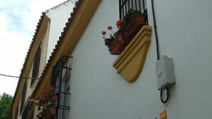 A building with a sign indicating 'Alcazar Hostal' and 'PARKING'. - Alcázar (Córdoba)