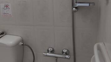 A small bathroom with a shower, toilet, and sink.