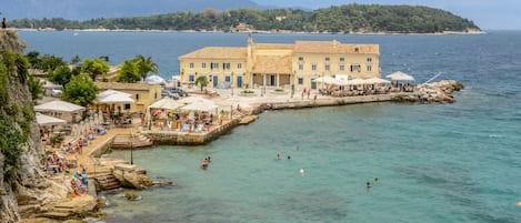 Un hotel frente al mar con piscina, zona de estar al aire libre y vistas al océano.
