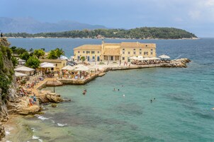 Un hotel frente al mar con piscina, zona de estar al aire libre y vistas al océano.