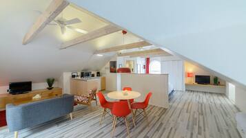 A modern loft apartment with a dining area, kitchen, and living space.