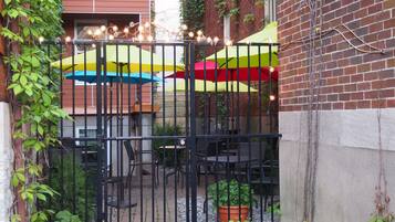 A gated patio area with outdoor seating and umbrellas.