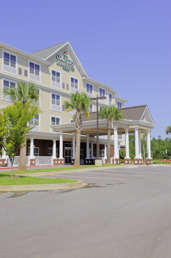 A multi-story hotel with a covered entrance and palm trees.