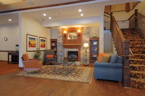 A spacious living room with a fireplace, a staircase, and a cozy seating area.