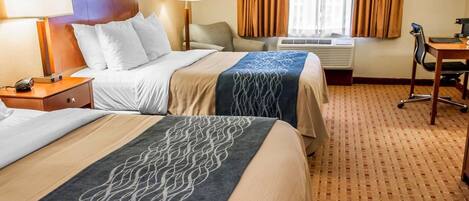 A hotel room with two beds, a desk, a chair, and a window with curtains.