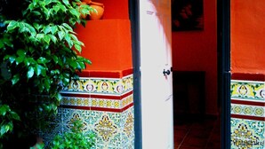 A doorway with a tiled base and a door, leading to a room with a tiled floor. - Hotel Al Andalus Jerez (Jerez de la Frontera)