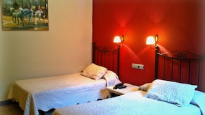 A room with two single beds, each with a white quilted bedspread and a pillow. There are two wall-mounted reading lamps on the headboard. - Hotel Al Andalus Jerez (Jerez de la Frontera)