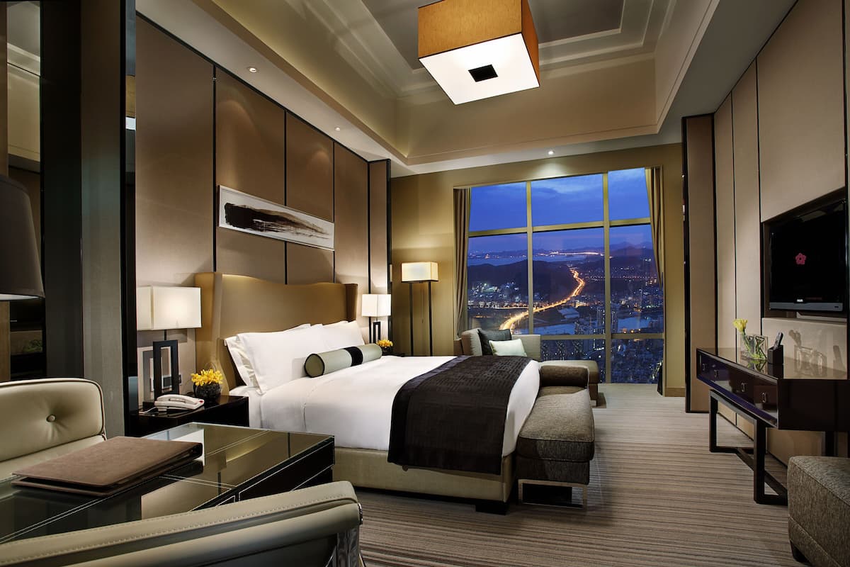 Une chambre d’hôtel moderne équipée d’un grand lit, d’un bureau, d’un canapé et d’une télévision.