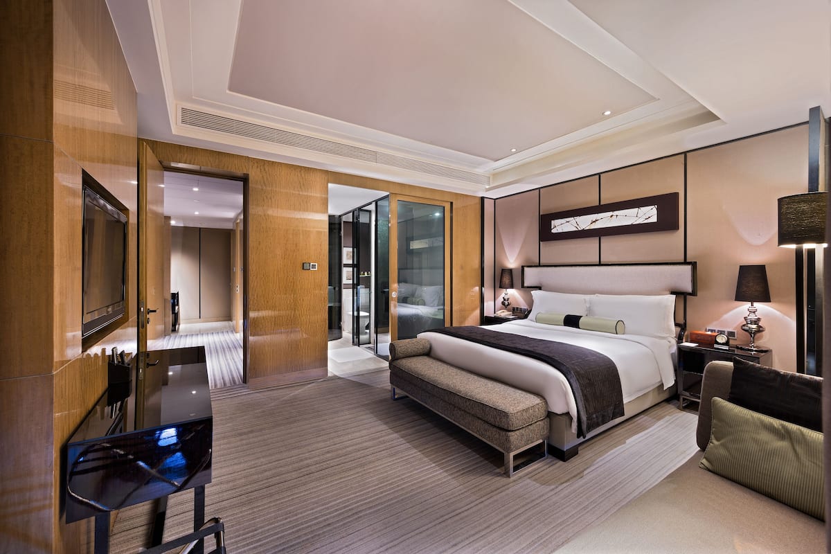 Une chambre d’hôtel moderne avec un grand lit, un bureau et une télévision.