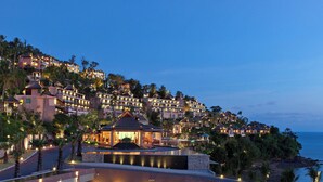A resort with multiple buildings, a pool, and a view of the ocean.