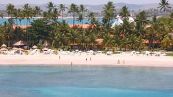 On the beach, white sand, sun loungers, beach umbrellas