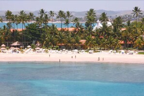 On the beach, white sand, sun loungers, beach umbrellas
