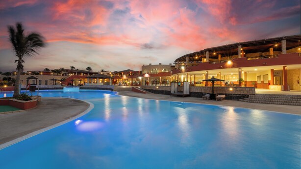 A swimming pool with a sunset sky in the background. - Occidental Boa Vista Beach (Boa Vista)