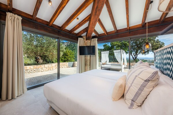 Un dormitorio con una cama grande, televisión y vistas al exterior.