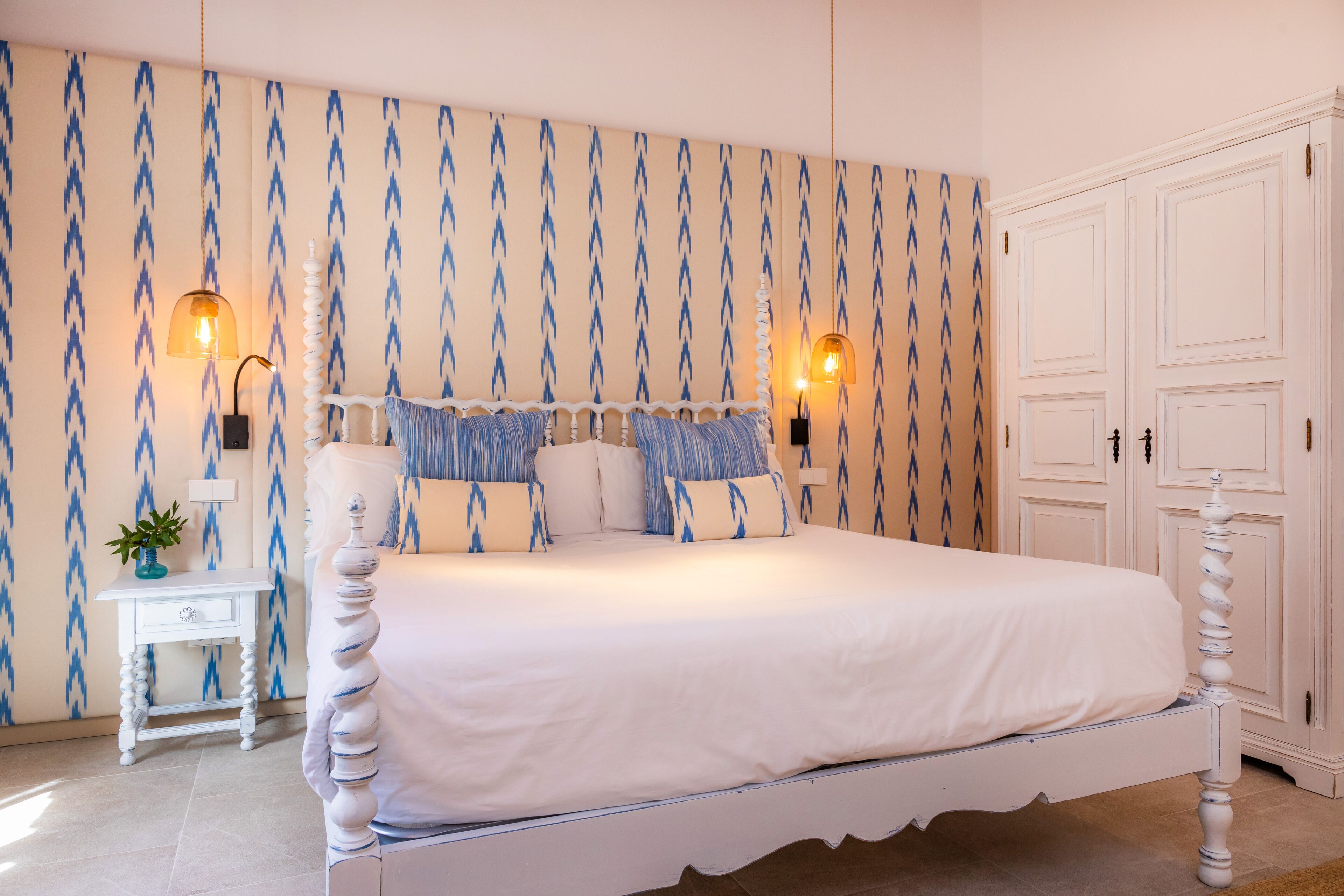 A bedroom with a bed, nightstands, and a wardrobe.