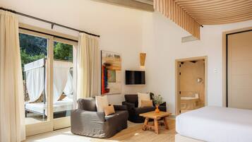 Ein modernes Schlafzimmer mit einem großen Bett, zwei Sofas, einem kleinen Tisch und einem Fernseher.