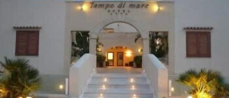 A hotel entrance with a sign reading "Tempo di mare HOTEL".